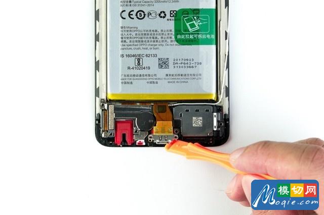 卸去底部螺絲后，利用翹片抬起底部的數據接口，在下方還會發現一枚螺絲。